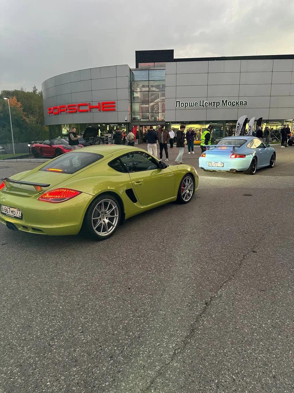 Салатовый Cayman R и голубой 911 (996) перед зданием центра