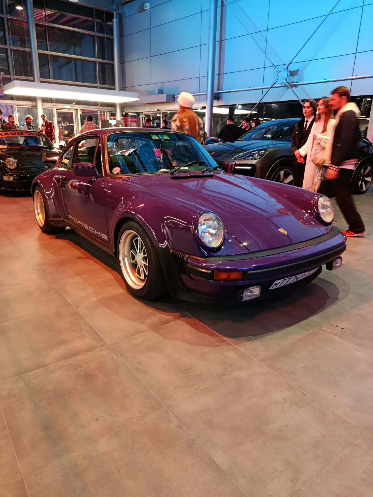 Фиолетовый 911 Turbo (930) в шоуруме, позади гости