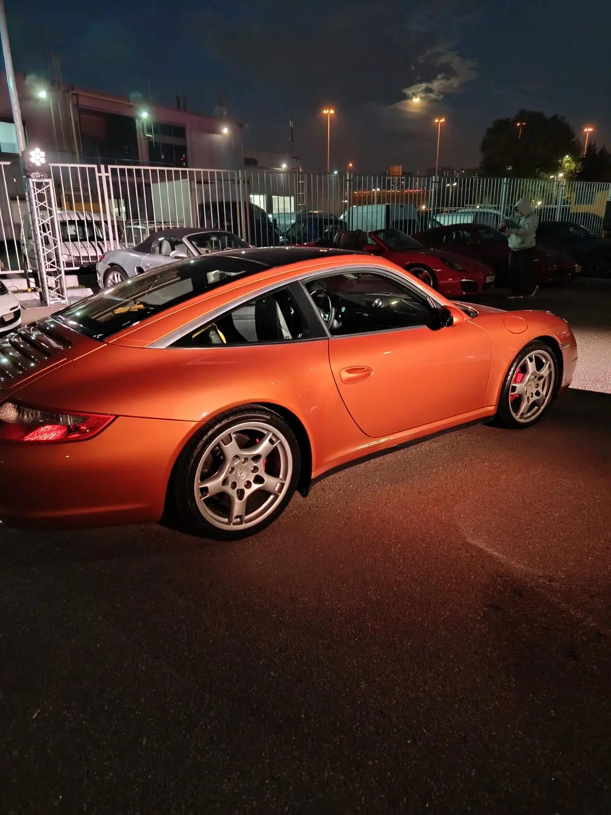 Оранжевый 911 Targa (997) на ночной парковке